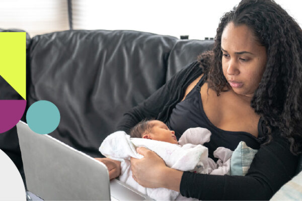black mother on laptop with newborn